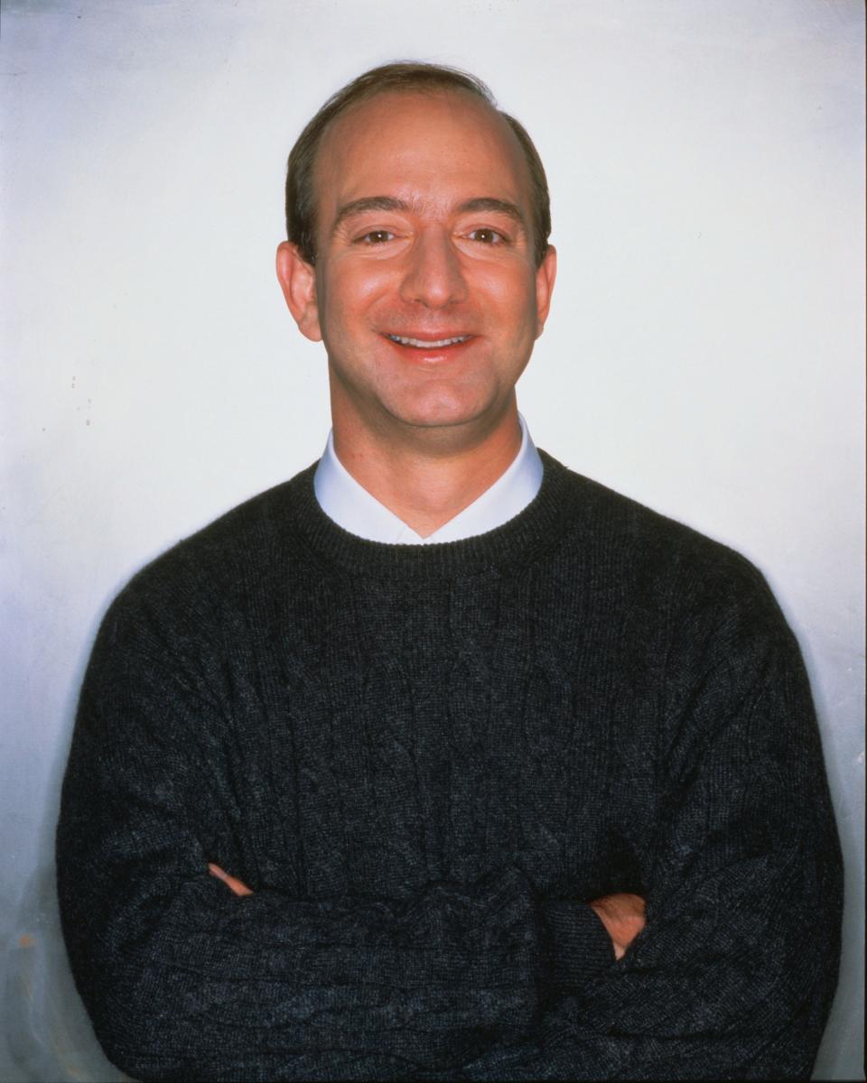 Jeff Bezos smiling whilst his arms are folded 