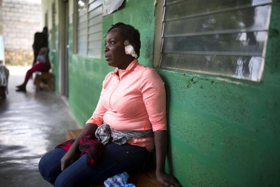 Shelda Similien, who ran out of her before it collapsed when a magnitude 5.9 earthquake hit the night before, waits to be treated at a local hospital in Gros Morne, Haiti, Sunday, Oct. 7, 2018. Similien's five year-old son died when he became buried by the rubble of the collapsed home. (AP Photo/Dieu Nalio Chery)