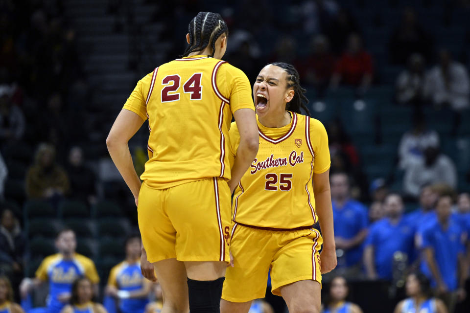 Southern California guard McKenzie Forbes (25) and Kaitlyn Davis celebrate Forbes' 3-point basket against UCLA during the first half of an NCAA college basketball in the semifinals of the Pac-12 women's tournament Friday, March 8, 2024, in Las Vegas. (AP Photo/David Becker)