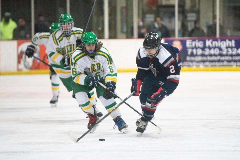 Trevor Simon, front left, battles for possession with a Liberty defender at the Pueblo Ice Arena in January.