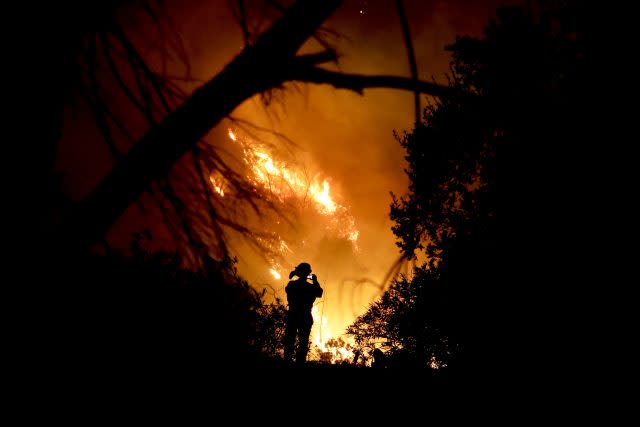 A firefighter takes a photo in Montecito (Chris Carlson/AP)