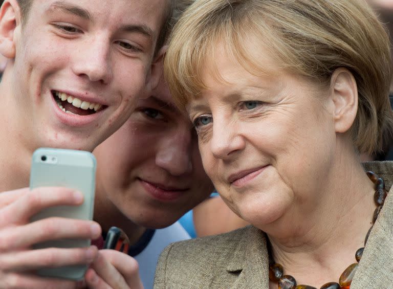 Merkel posa para una selfie con estudiantes de una escuela en 2014