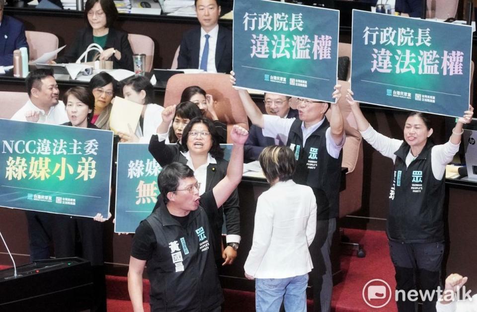 立法院新會期今開議，民眾黨立委在行政院長卓榮泰面前舉牌杯葛議事，民進黨立委王美惠則是手比愛心反制。   圖：張良一/攝