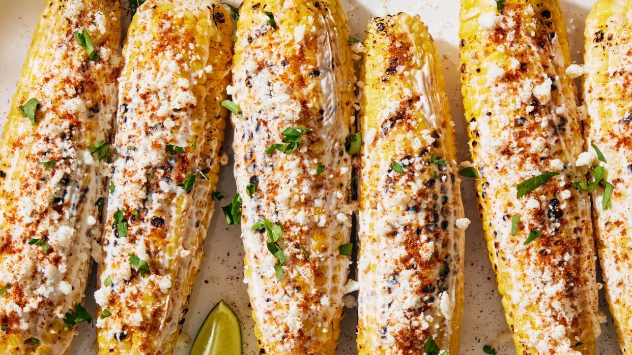 grilled corn topped with a creamy mixture, cotija cheese, chili powder, cilantro and lime