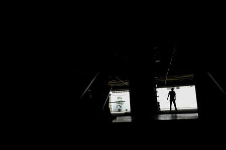 A man walks at a parking garage during a blackout in Caracas, Venezuela February 6, 2018. REUTERS/Carlos Garcia Rawlins