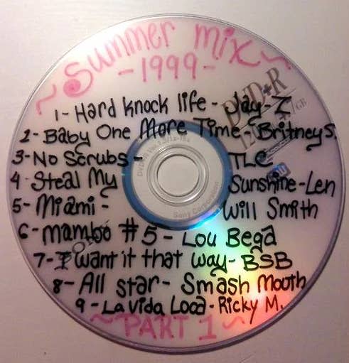 Handwritten tracklist on a 'Summer Mix 1999' CD featuring artists like Jay-Z and Britney Spears