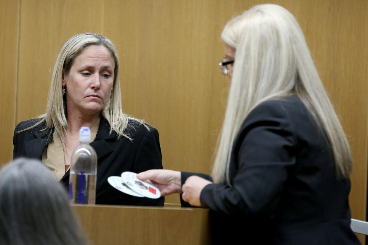 Lindsay Carnevale, an emergency room nurse at Southern Ocean County Medical Center, looks at DVDs held by Assistant Ocean County Prosecutor Christine Lento during Christopher Gregor's trial before Superior Court Judge Guy P. Ryan in Toms River Tuesday, May 7, 2024. Gregor is charged with the 2021 murder and child endangerment of his 6-year-old son Corey Micciolo.