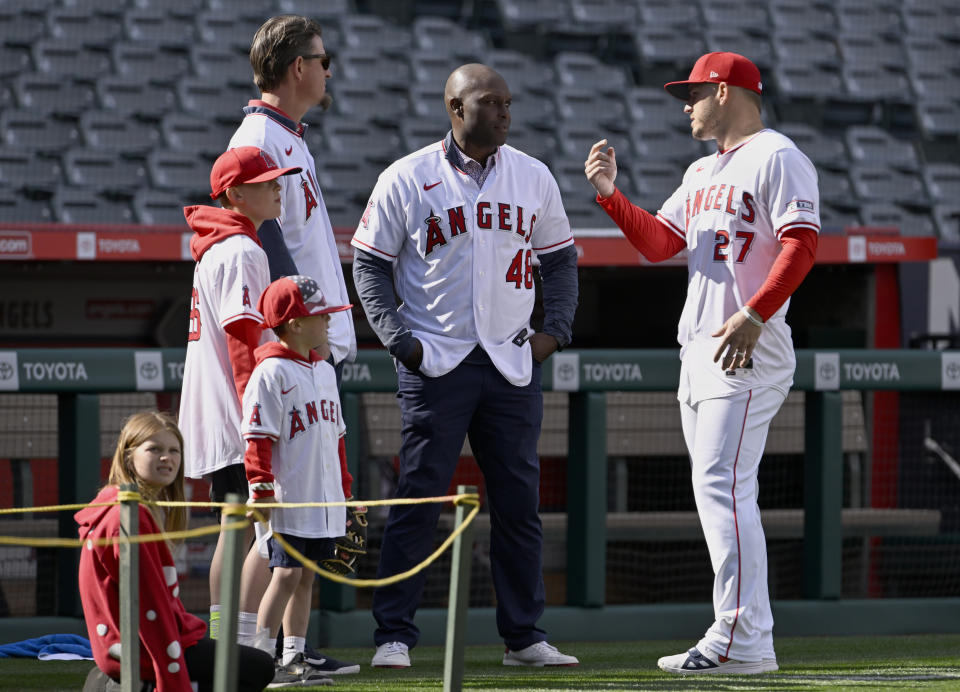 Los Angeles Angels outfielder Mike Trout (27) talks with former baseball players Jered Weaver, left and Torii Hunter during warmups before the Angels' home-opener baseball game gainst the Boston Red Sox in Anaheim, Calif., Friday, April 5, 2024. (AP Photo/Alex Gallardo)