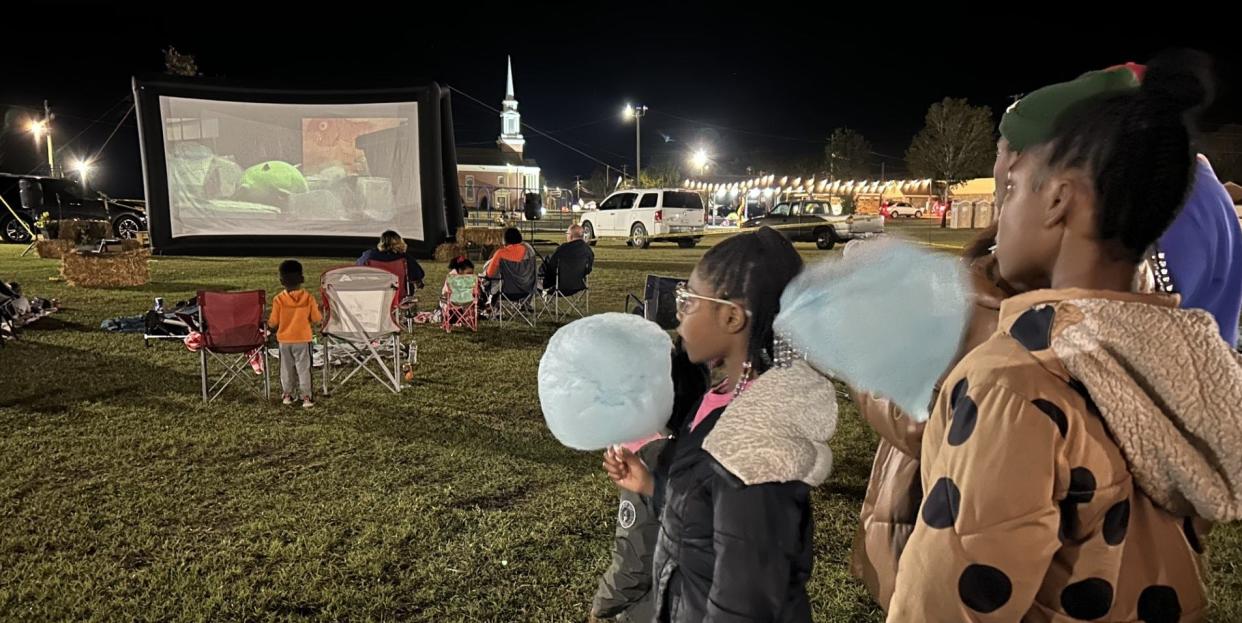 Children enjoy cotton candy from a vendor at the outdoor screening of Monsters Inc. movie night event opening the October Fun Fest events in Wrens.
