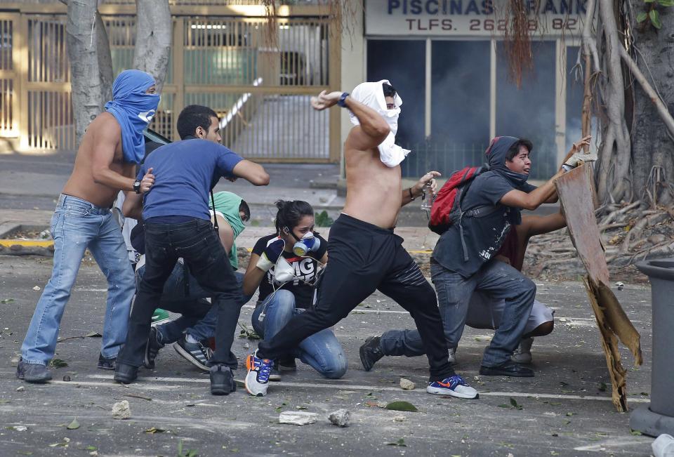 Demonstrators confront police as they protest against the government of President Nicolas Maduro in Caracas, February 22, 2014. A female student and a young supermarket worker were the latest fatalities from Venezuela's political unrest as the death toll from 10 days of violence rose on Saturday to at least eight. REUTERS/Carlos Garcia Rawlins (VENEZUELA - Tags: CIVIL UNREST POLITICS TPX IMAGES OF THE DAY)