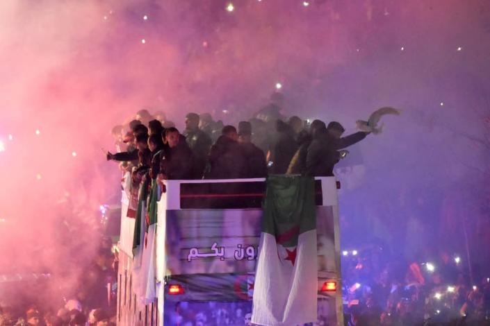 Algeria&#39;s national football team celebrates on a bus with their fans in Algiers, on December 19, 2021, a day after winning the FIFA Arab Cup 2021. - Africa Cup of Nations holders Algeria won the Arab Cup on December 18, beating Tunisia 2-0 after extra time in Qatar.