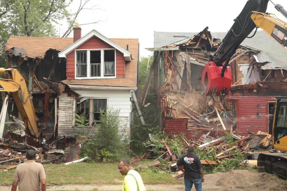 Demolition crews tear down abandoned houses on Turner Street in Detroit in August 2013 following a press conference to kick off the state's largest residential blight removal effort. Five abandoned houses were demolished on the same block.