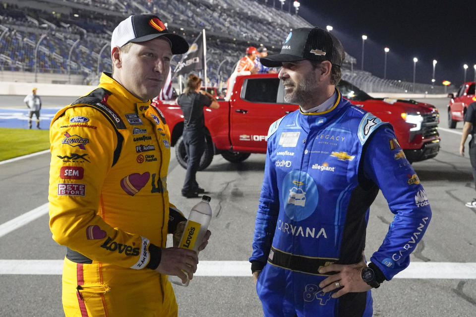 Michael McDowell, left, and Jimmie Johnson talk on pit road before the first of two qualifying auto races for the NASCAR Daytona 500 at Daytona International Speedway, Thursday, Feb. 16, 2023, in Daytona Beach, Fla. (AP Photo/John Raoux)