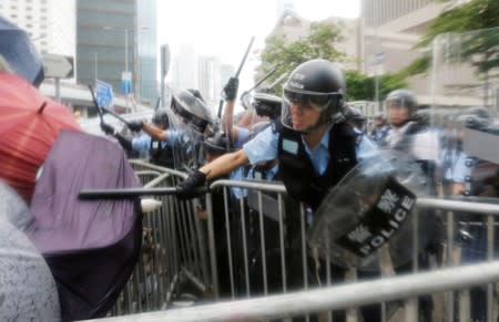 FILE PHOTO: Protesters protect themselves with umbrellas as they clash with riot police during a demonstration against a proposed extradition bill, near the Legislative Council in Hong Kong