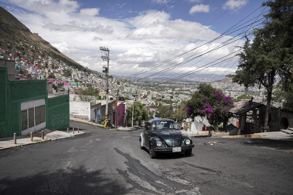 Janette Navarro maneja su Beetle Volkswagen de 1996 por una empinada colina del vecindario de Cuautepec, en Ciudad de México, el viernes 21 de junio de 2024. Los taxistas como Navarro dicen que siguen utilizando los vochos porque los autos son asequibles y el motor situado en la parte trasera del vehículo les da más potencia para trepar las empinadas cuestas del vecindario. (AP Foto/Aurea Del Rosario)