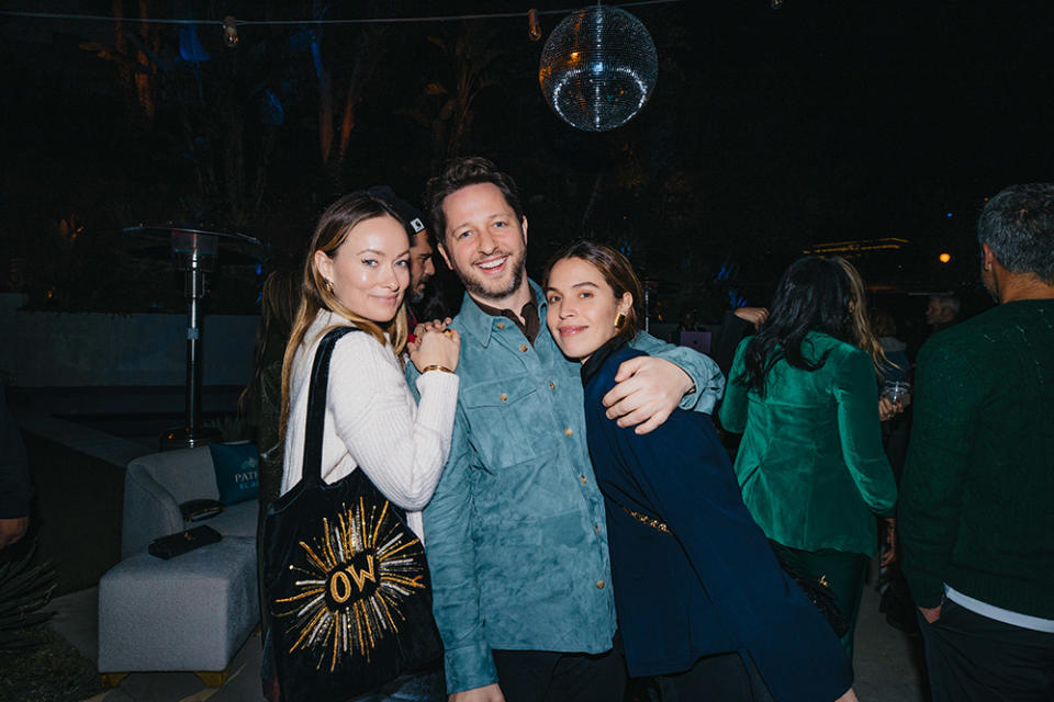 Derek Blasberg is flanked by Olivia Wilde and Cleo Wade at his holiday celebration hosted by PATRON EL CIELO in Beverly Hills.