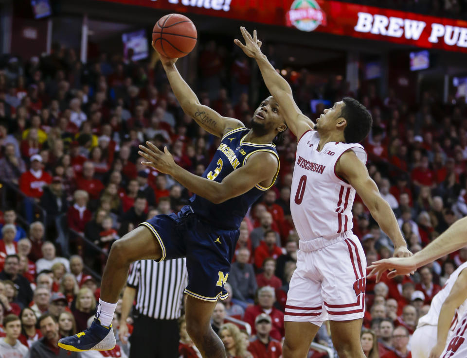 Michigan’s Zavier Simpson (3) shoots against Wisconsin’s D’Mitrik Trice (0) on Saturday in Madison, Wis. (AP)