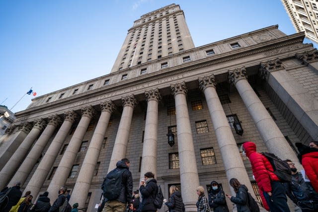 A line of people, mostly journalists, wait to enter the courthouse (John Minchillo/AP)