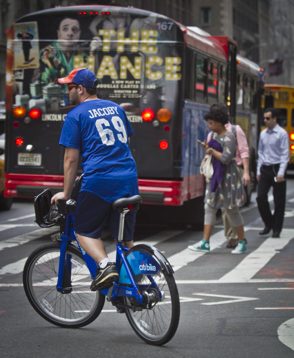 In this Tuesday, June 25, 2013, photo, a biker rides without a helmet on a Citibike, as part of New York City's bike sharing system, in New York. Under Mayor Bloomberg, the city has cracked down on smoking, fatty foods and sugary drinks for health concerns, but the nations largest bike-share program allow riders without helmets. (AP Photo/Bebeto Matthews)