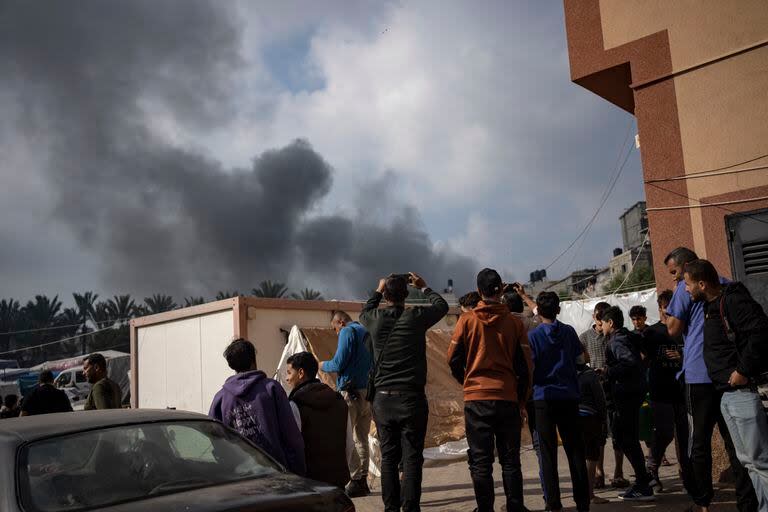 Palestinos observan el humo tras un ataque aéreo israelí en Jan Yunis, en la Franja de Gaza, el viernes 1 de diciembre de 2023.