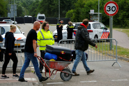 Visitiors leave the festival grounds as police are seen near a scene where a van struck into people after a concert in Landgraaf, the Netherlands June 18, 2018. REUTERS/Thilo Schmuelgen