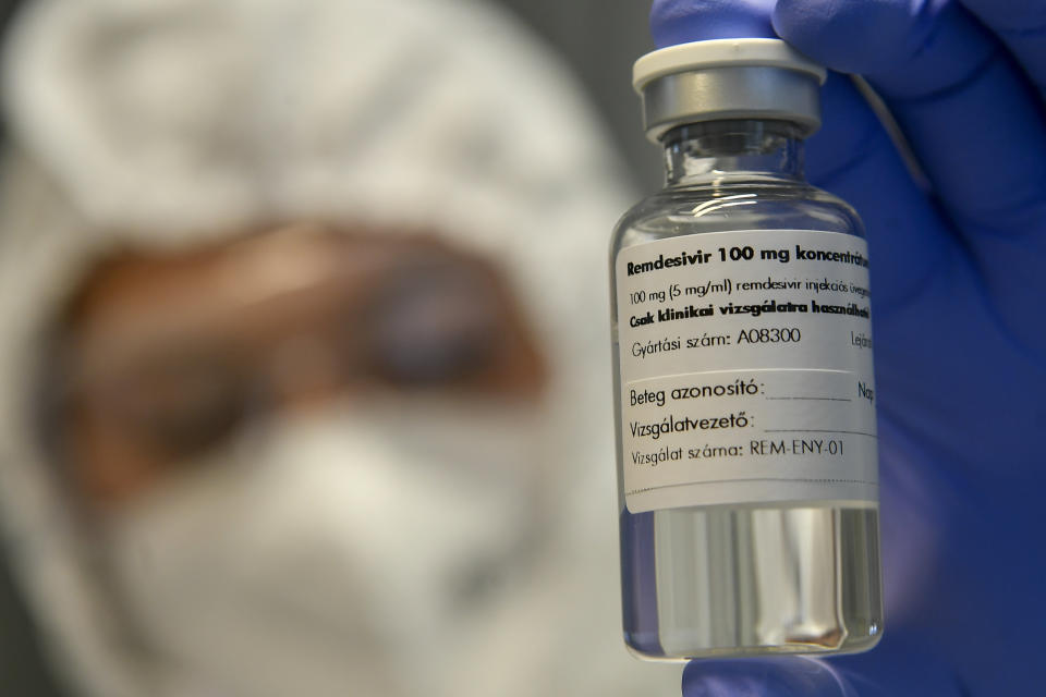 A bottle containing the drug Remdesivir is held by a health worker at the Institute of Infectology of Kenezy Gyula Teaching Hospital of the University of Debrecen in Debrecen, Hungary, Thursday Oct. 15, 2020. A large study led by the World Health Organization released on Friday, Oct. 16, 2020, suggests that the antiviral drug did not help hospitalized COVID-19 patients, in contrast to an earlier study that made the medicine a standard of care in the United States and many other countries. The results do not negate the previous ones, and the WHO study was not as rigorous as the earlier one led by the U.S. National Institutes of Health. But they add to concerns about how much value the pricey drug gives because none of the studies have found it can improve survival. (Zsolt Czegledi/MTI via AP)