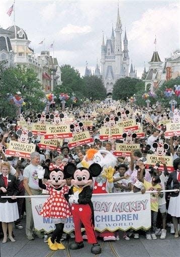 Mickey and Minnie Mouse lead a group of 4000 children from 116 cities down Main Street USA during Mickey Mouseís 60th birthday party at Walt Disney World in Lake Buena Vista, Florida on Nov. 18, 1988.