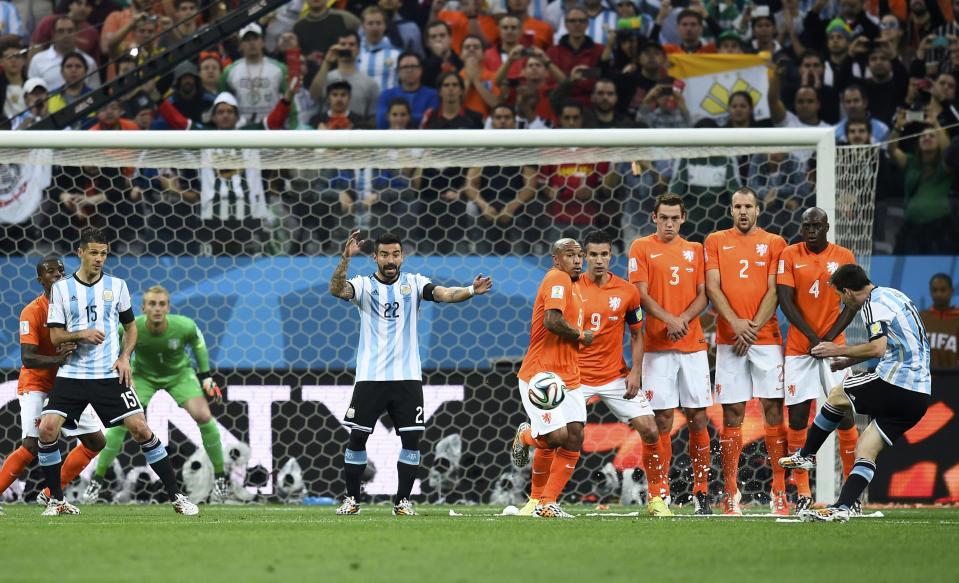 Argentina's Messi takes a free kick near Netherlands' players during their 2014 World Cup semi-finals at the Corinthians arena in Sao Paulo