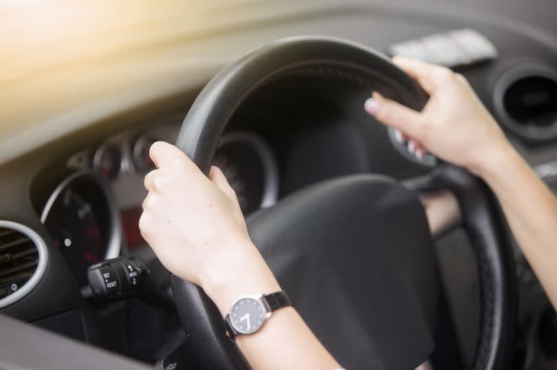 Pictured is two hands on a steering wheel