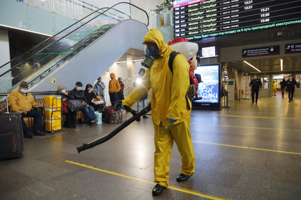 An employee of the Federal State Center for Special Risk Rescue Operations of Russia Emergency Situations disinfects Leningradsky railway station in Moscow, Russia, Tuesday, Oct. 19, 2021. Russia registered another daily record of coronavirus deaths Tuesday as rapidly surging contagion raised pressure on the country's health care system. The daily coronavirus mortality numbers have been surging for weeks and topped 1,000 for the first time over the weekend amid sluggish vaccination rates and the government's reluctance to toughen restrictions. (AP Photo/Alexander Zemlianichenko Jr)