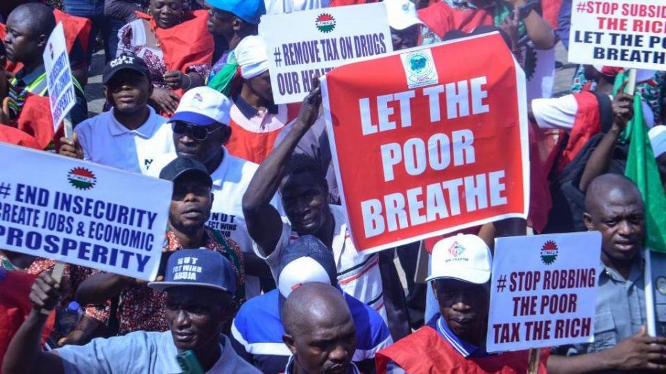 Protesters with the Nigeria Labour Congress (NLC) gather at the National Assembly while holding placards during a protest against the recent raise in cost of living/economic hardship across the country in Abuja on February 27, 2024