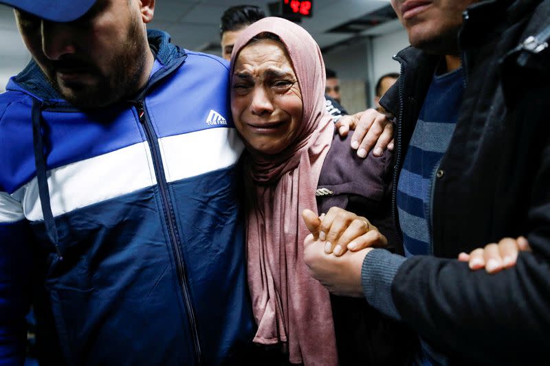 People react near the body of a Palestinian at a hospital near Ramallah