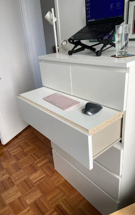 the drawer to the dresser pulled out and a self put on top to create a flat surface for the mouse and keyboard