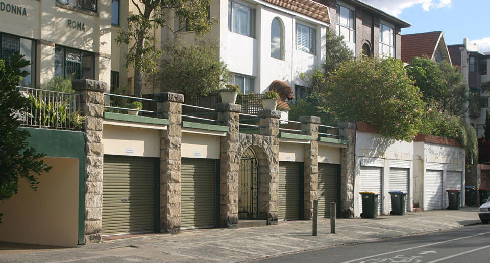 A row of apartments with garages at ground level. 