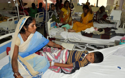 Family members care for children undergoing treatment at the Baba Raghav Das Hospital - Credit: EPA