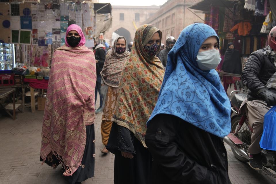 Women, wearing masks, visit a market in Lahore, Pakistan, Monday, Jan. 15, 2024. The shopping website Daraz has reported a spike in searches for air purifiers and face masks since last October, especially in Punjab. (AP Photo/K.M. Chaudary)