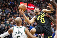 Utah Jazz guard Talen Horton-Tucker (0) takes on off-balance shot while Milwaukee Bucks guard Jevon Carter, left, looks on during the first half of an NBA basketball game Friday, March 24, 2023, in Salt Lake City. (AP Photo/Adam Fondren)