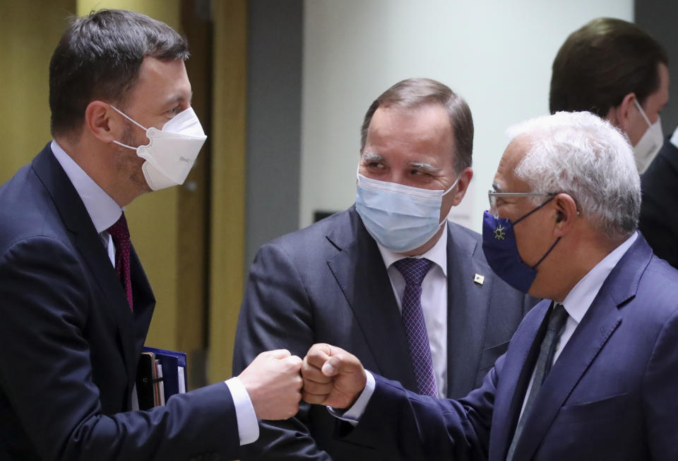 Slovakia's Prime Minister Eduard Heger, left, greets Portugal's Prime Minister Antonio Costa, right, with a fist bump during a round table meeting at an EU summit in Brussels, Monday, May 24, 2021. European Union leaders are expected, during a two day in-person meeting, to focus on foreign relations, including Russia and the UK. (Yves Herman, Pool via AP)