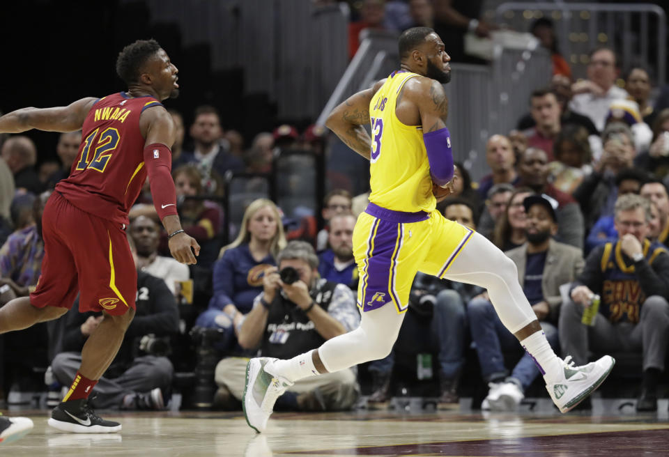 Los Angeles Lakers' LeBron James, right, drives to the basket past Cleveland Cavaliers' David Nwaba during the first half of an NBA basketball game Wednesday, Nov. 21, 2018, in Cleveland. (AP Photo/Tony Dejak)