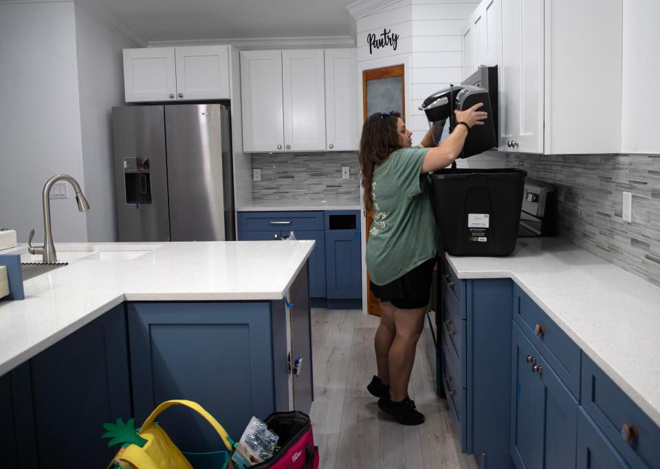 Amber Redfern unpacks a bin in her mom's kitchen on Friday, Oct. 27, 2023, in Fort Myers. Redfern's mom, Linda, is excited to finally move back into her condo after it was flooded in Hurricane Ian.