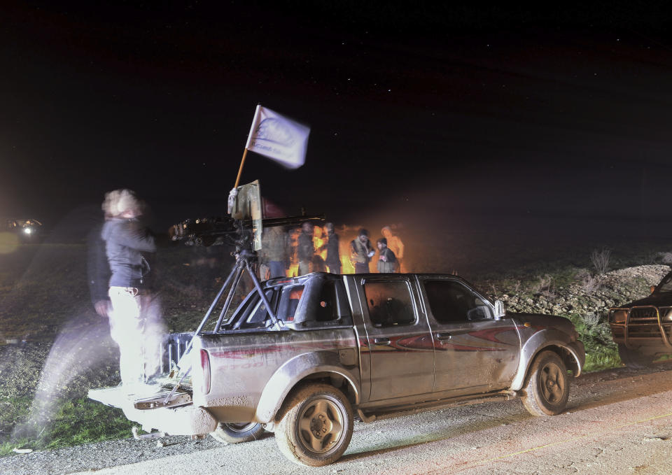 In this photo taken late Friday, Dec. 28, 2018, Turkey-backed Free Syrian Army soldiers gather near the northern Syrian city of Manbij. Syria's military announced Friday that it entered the flashpoint Kurdish-held town of Manbij, where Turkey has threatened an offensive and raised the national flag there. (DHA via AP)