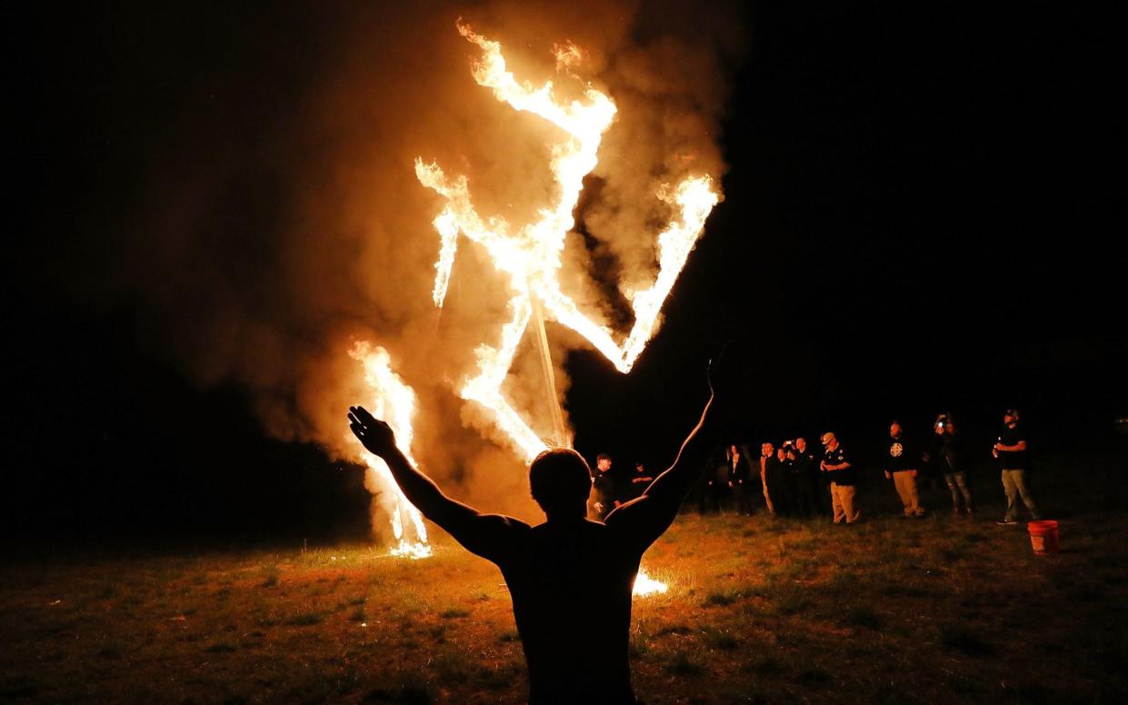 Members of the National Socialist Movement, one of the largest neo-Nazi groups in the US, hold a swastika burning after a rally on April 21, 2018 - Spencer Platt 