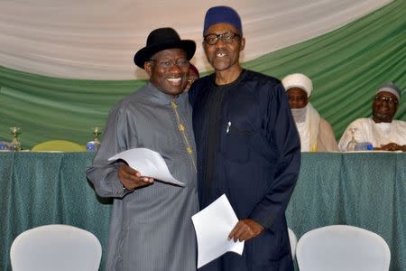 Nigeria's President Goodluck Jonathan (L) and former military ruler Muhammadu Buhari embrace after signing a peace accord in Abuja March 26, 2015. REUTERS/Stringer