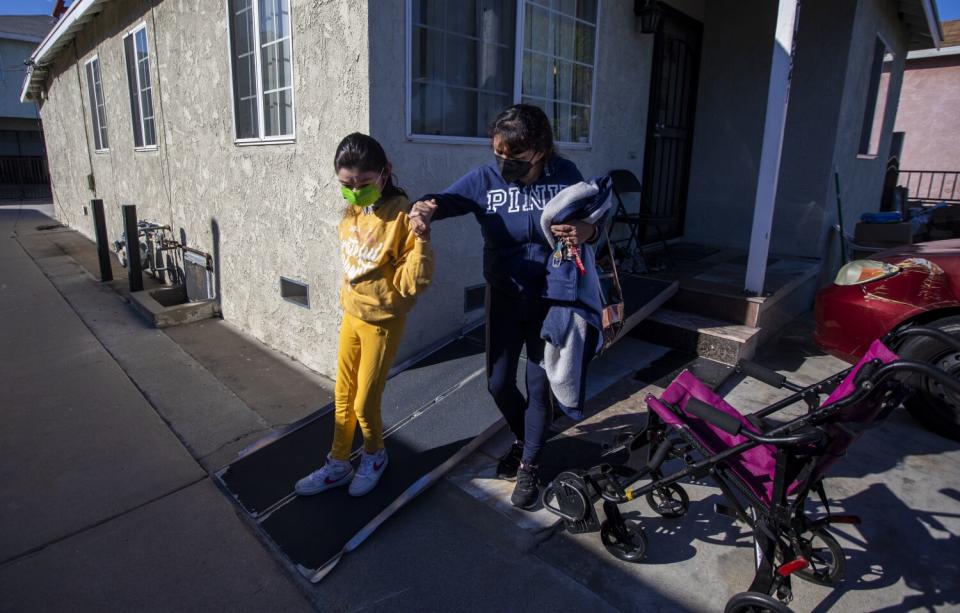 Andresen, right, walks with her daughter down a ramp outside their rented home