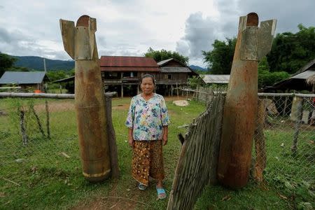 A woman poses at an entrance of her house next to bombs dropped by the U.S. Air Force planes during the Vietnam War, in the village of Ban Napia in Xieng Khouang province, Laos September 3, 2016. REUTERS/Jorge Silva