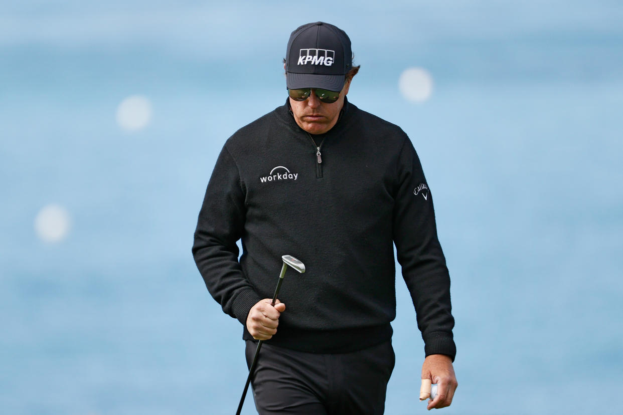 Phil Mickelson sighs at his club.