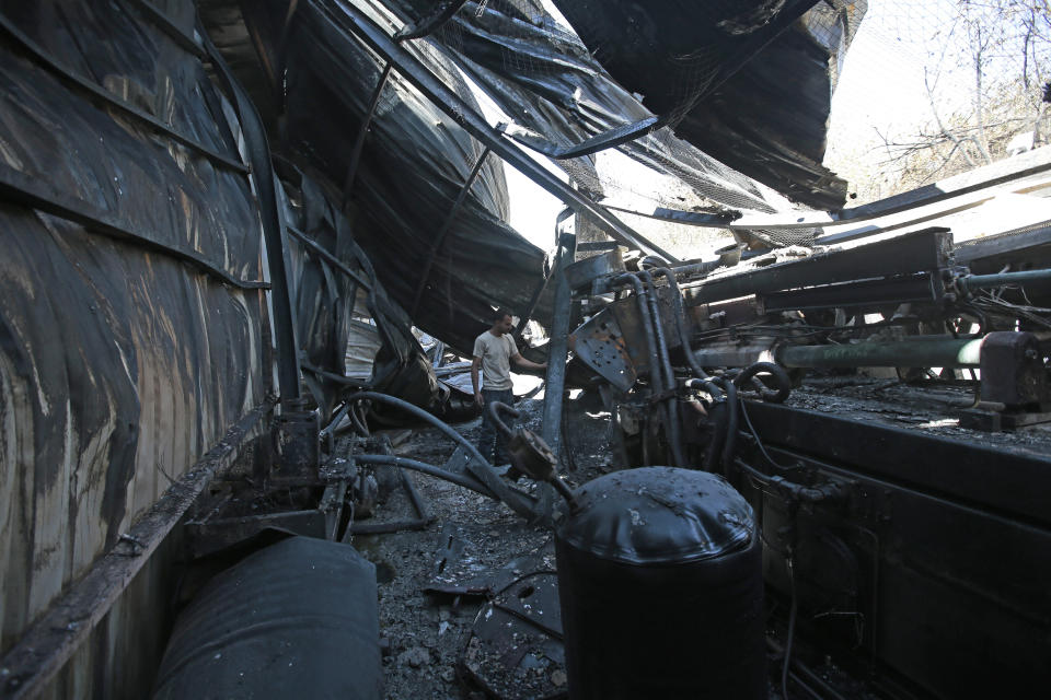 A worker inspects the damage to a plastic materials factory destroyed by Saudi-led airstrikes, in Sanaa, Yemen, Tuesday, Nov. 23, 2021. (AP Photo/Hani Mohammed)