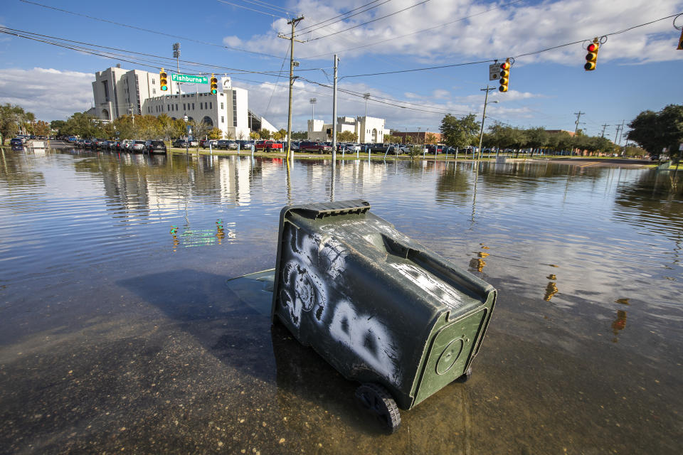 A trash container floats at the intersection of Fishburne St. and Hagood Ave. as a king tide rolls into historic Charleston, S.C. Sunday, Nov. 15, 2020. Charleston has remained relatively unscathed this hurricane season. That means more time to mull a $1.75 billion proposal by the Army Corps of Engineers that features a sea wall along the city's peninsula to protect it from deadly storm surge during hurricanes. (AP Photo/Mic Smith)