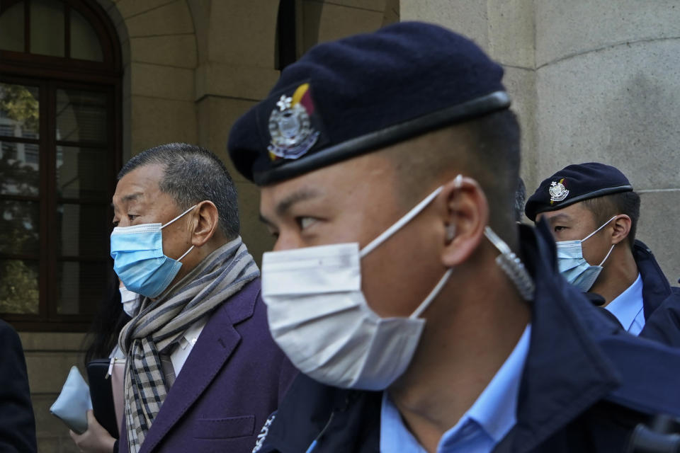 Hong Kong pro-democracy activist and media tycoon Jimmy Lai, left, leaves the Court of Final Appeal during a break in Hong Kong, Thursday, Dec. 31, 2020. Lai appeared in court Thursday as prosecutors asked the city's top judges to send him back to detention after he was granted bail last week on fraud and national security-related charges. (AP Photo/Kin Cheung)