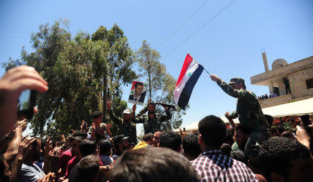 Residents celebrate the army's arrival in the formerly rebel-held town of Ibta, northeast of Deraa city, Syria in this handout released on June 29, 2018. SANA/Handout via REUTERS